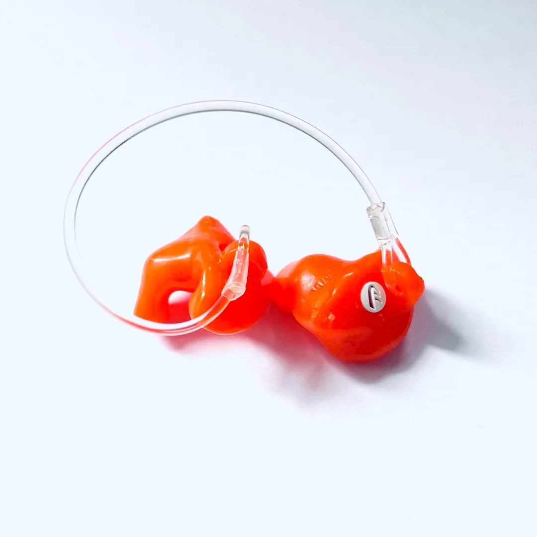 A pair of Qui8 Db custom-molded earplugs in safety orange silicone, joined by a clear retention cord
